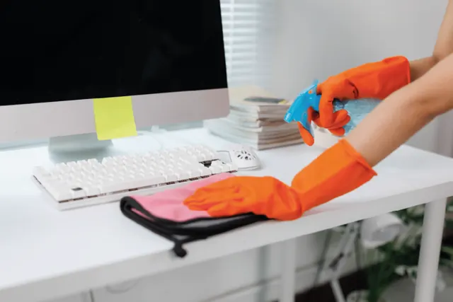 Bureau wordt schoongemaakt met handschoenen